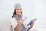 Cheerful pretty brunette with winter hat on buying online