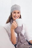 Cheerful brunette with winter hat on holding cup of coffee