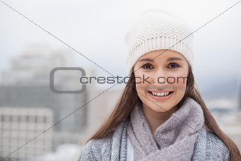 Smiling cute brunette with winter clothes on posing