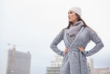 Unsmiling pretty brunette with winter clothes on posing