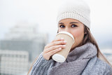 Gorgeous brunette with winter clothes on drinking coffee