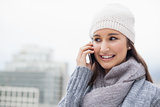 Cheerful brunette with winter clothes on having a call
