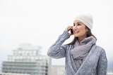 Relaxed brunette with winter clothes on having a call