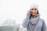 Smiling woman with winter clothes on having a call