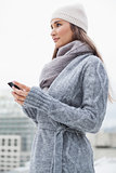Peaceful woman with winter clothes on text messaging