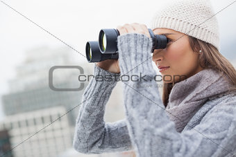Gorgeous woman with winter clothes on using binoculars