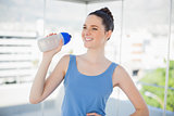 Happy fit woman holding plastic flask