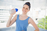 Smiling slender woman holding plastic flask