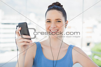 Cheerful slender woman listening to music