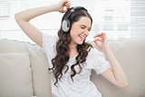 Smiling young woman dancing while listening to music