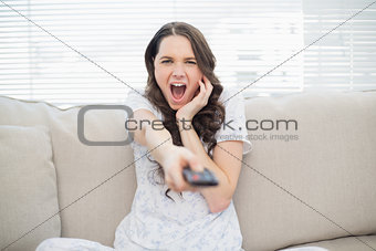 Scared young woman changing tv station