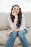Smiling casual woman sitting on a cosy couch