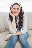 Cheerful casual woman sitting on a cosy couch