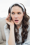 Pretty casual woman being surprised on the phone