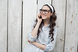Trendy young woman with stylish glasses having phone call