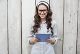 Trendy young woman with stylish glasses using tablet pc
