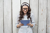 Trendy young woman with stylish glasses using her tablet