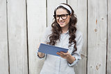Smiling trendy woman with stylish glasses using her tablet