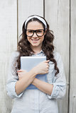 Cheerful trendy woman with stylish glasses holding her tablet