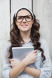 Pensive trendy woman with stylish glasses holding her tablet
