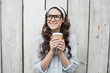 Pensive trendy woman with stylish glasses holding coffee