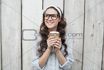Pensive trendy woman with stylish glasses holding coffee