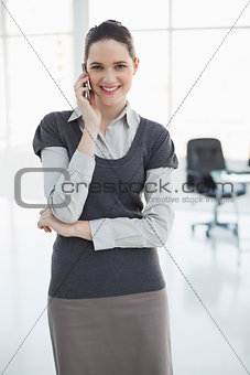 Cheerful businesswoman on the phone posing