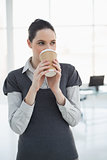 Pretty young businesswoman drinking coffee
