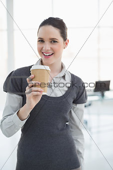 Smiling young businesswoman holding coffee