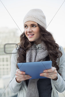 Cheerful pretty brunette holding her tablet