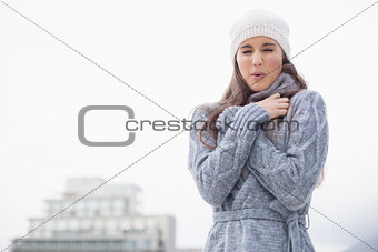 Shivering pretty woman with winter clothes on posing
