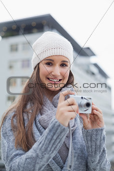 Smiling gorgeous woman with winter clothes on taking picture