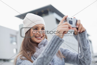 Smiling gorgeous woman with winter clothes on taking a self picture