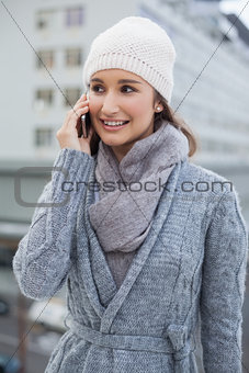 Smiling gorgeous woman wearing winter clothes having a call