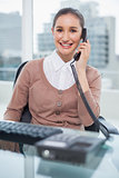 Smiling businesswoman picking up the phone