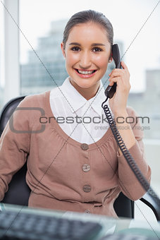 Cheerful businesswoman picking up the phone