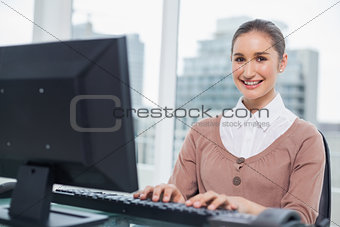 Cheerful gorgeous businesswoman working on her computer