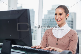Smiling gorgeous businesswoman working on her computer