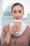 Happy gorgeous businesswoman smelling coffee