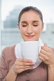 Relaxed gorgeous businesswoman holding cup of coffee