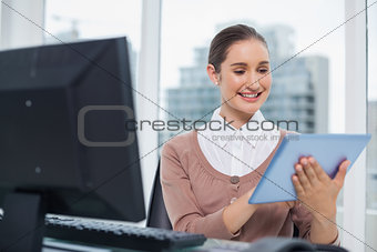 Cheerful beautiful businesswoman using her tablet