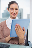 Happy beautiful businesswoman scrolling on her tablet
