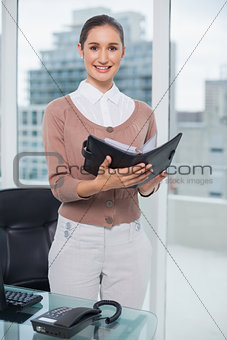 Smiling businesswoman holding notebook