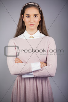 Stern young model with pink dress on posing