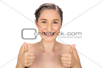 Smiling woman giving thumbs up to camera