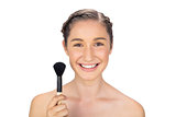 Smiling gorgeous model holding blusher brush
