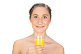 Greedy gorgeous model holding glass of orange juice