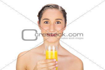 Greedy gorgeous model holding glass of orange juice