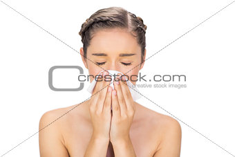 Sick young model blowing her nose