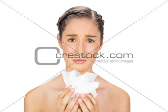 Sad young model holding loads of tissues